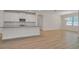 Bright, open-concept living space with wood floors, modern kitchen with white cabinetry at 11512 Weaver Hollow Rd, New Port Richey, FL 34654
