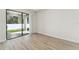 Open living area features light wood flooring and sliding glass doors providing access to the outdoor patio at 11512 Weaver Hollow Rd, New Port Richey, FL 34654