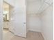Walk-in closet features carpet flooring, wire rack shelving, and an open door to the primary bathroom at 11512 Weaver Hollow Rd, New Port Richey, FL 34654