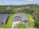 An aerial view captures the property's spacious lot and mature trees, with blue accents on the facade at 6109 Dusk Rose Ln, Brooksville, FL 34601