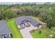 Aerial view of an elegant single-Gathering home with a lush green yard and mature trees in the background at 6109 Dusk Rose Ln, Brooksville, FL 34601