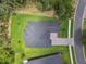 Birds eye view of a meticulously landscaped property, displaying a patterned driveway, manicured lawns, and mature trees at 6109 Dusk Rose Ln, Brooksville, FL 34601