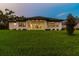 The home's back exterior offers ample space and natural light, with manicured grass extending to the tree line at 6109 Dusk Rose Ln, Brooksville, FL 34601