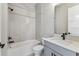 Bathroom with grey vanity, modern fixtures, and tiled shower at 6109 Dusk Rose Ln, Brooksville, FL 34601