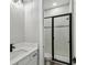 Modern bathroom with white tile shower, glass doors, and quartz countertop at 6109 Dusk Rose Ln, Brooksville, FL 34601