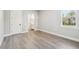 Bright bedroom with gray walls, light wood floors, a white door, and a window with a view at 6109 Dusk Rose Ln, Brooksville, FL 34601