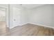 Bright bedroom with light gray walls, a light wood floor, a white door, and white trim at 6109 Dusk Rose Ln, Brooksville, FL 34601