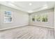 Bright bedroom with tray ceiling, wood floors, and multiple windows at 6109 Dusk Rose Ln, Brooksville, FL 34601