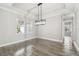 Bright dining room featuring wood floors, a modern light fixture, large windows, and elegant crown molding at 6109 Dusk Rose Ln, Brooksville, FL 34601