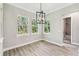 Bright dining room with gray-tone floors, and view into the bathroom at 6109 Dusk Rose Ln, Brooksville, FL 34601