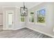 Dining room with gray-tone floors, modern lighting and view into lanai at 6109 Dusk Rose Ln, Brooksville, FL 34601
