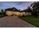 Stunning exterior featuring a brick driveway, lush lawn, and attached garage enhancing the curb appeal of this elegant home at 6109 Dusk Rose Ln, Brooksville, FL 34601