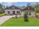 Beautiful home exterior featuring a well-manicured lawn, paver driveway and a welcoming columned porch at 6109 Dusk Rose Ln, Brooksville, FL 34601