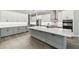 This kitchen features a large island with white countertops and gray cabinets and stainless appliances at 6109 Dusk Rose Ln, Brooksville, FL 34601