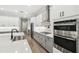 Gourmet kitchen featuring stainless steel appliances, white cabinets, a large island, and a modern vent hood at 6109 Dusk Rose Ln, Brooksville, FL 34601
