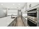 Modern kitchen boasts stainless steel appliances and stylish white and gray cabinetry at 6109 Dusk Rose Ln, Brooksville, FL 34601