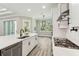 Bright kitchen with stainless appliances, gray-tone floors, and white cabinets at 6109 Dusk Rose Ln, Brooksville, FL 34601