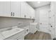 White laundry room with white cabinets, a sink, and modern fixtures at 6109 Dusk Rose Ln, Brooksville, FL 34601