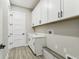 Well-lit laundry room with sink and overhead cabinets at 6109 Dusk Rose Ln, Brooksville, FL 34601