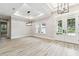 Spacious living room with natural light, wood flooring, and elegant lighting fixtures creating a welcoming atmosphere at 6109 Dusk Rose Ln, Brooksville, FL 34601
