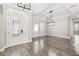 Open living space with wood floors, modern lighting, and a decorative glass front door at 6109 Dusk Rose Ln, Brooksville, FL 34601