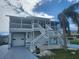 Two-story home featuring double staircases, a garage, and a charming, elevated porch with a palm tree at 6428 Driftwood Dr, Hudson, FL 34667