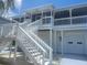 Elevated home with staircase leading to covered porch and upper-level living spaces at 6428 Driftwood Dr, Hudson, FL 34667