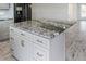 Close up view of kitchen island with granite countertops and gray cabinets at 6428 Driftwood Dr, Hudson, FL 34667