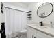 Small bathroom with white vanity, shower, and black accents at 9142 Brooker Dr, New Port Richey, FL 34655