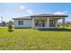 Home exterior showcasing a covered patio and grassy yard at 11313 Limpkin Rd, Weeki Wachee, FL 34614