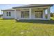 Home exterior showcasing a covered patio and grassy yard at 11313 Limpkin Rd, Weeki Wachee, FL 34614