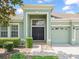 Two-story house with a green facade, double front doors, and a two-car garage at 4264 Braemere Dr, Spring Hill, FL 34609