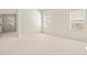 Well-lit bedroom with neutral walls, carpeted floors, and access to another room at 4264 Braemere Dr, Spring Hill, FL 34609