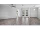 Bright and spacious living room with wood-look flooring and french doors at 6428 Driftwood Dr, Hudson, FL 34667