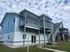 Two-story light-blue home with extended deck, balcony, and outdoor staircase at 6428 Driftwood Dr, Hudson, FL 34667