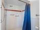 Walk-in shower with grab bars and a blue shower curtain at 6428 Driftwood Dr, Hudson, FL 34667