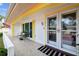 Charming front porch featuring double doors, tile flooring, and comfortable seating with bright yellow accents at 12212 Buttonwood Row, Hudson, FL 34667