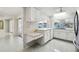 Bright kitchen area with white cabinetry, tile backsplash, and a view of the screened patio area at 12212 Buttonwood Row, Hudson, FL 34667