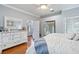 Main bedroom with white dresser, ruffled bedding, and hardwood floors at 20804 Eustis Rd, Land O Lakes, FL 34637