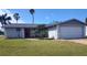 Single Gathering home with gray exterior, well manicured lawn, and a red front door at 3544 Wilson Dr, Holiday, FL 34691
