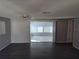 Bright living room with dark wood floors, ceiling fan, and sliding glass doors to a sunroom at 3544 Wilson Dr, Holiday, FL 34691