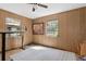 Spacious bedroom with wood paneling and a ceiling fan at 8812 Camp Ln, Hudson, FL 34667