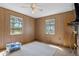 Bright bedroom with wood paneling and two windows at 8812 Camp Ln, Hudson, FL 34667
