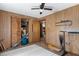 Bedroom with wood paneling, ceiling fan, and built-in closet at 8812 Camp Ln, Hudson, FL 34667