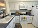 Bright kitchen features white cabinets, a double sink, and modern appliances at 11120 Carriage Hill Dr # 2, Port Richey, FL 34668