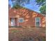 Back of house with orange siding and a small yard at 9468 Forest Hills Cir, Tampa, FL 33612