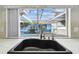 Kitchen with black farmhouse sink and a window overlooking the pool at 12212 Buttonwood Row, Hudson, FL 34667