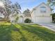 Two-story house with a two-car garage, manicured lawn, and mature trees at 2216 Waterfall Dr, Spring Hill, FL 34608