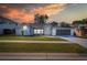 Single-story house with gray exterior, landscaped yard, and screened-in porch at 10412 Ventura Dr, Spring Hill, FL 34608