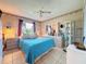 Well-lit bedroom showcases a queen-sized bed, accent furniture, and a decorative ceiling fan at 10824 Peppertree Ln, Port Richey, FL 34668
